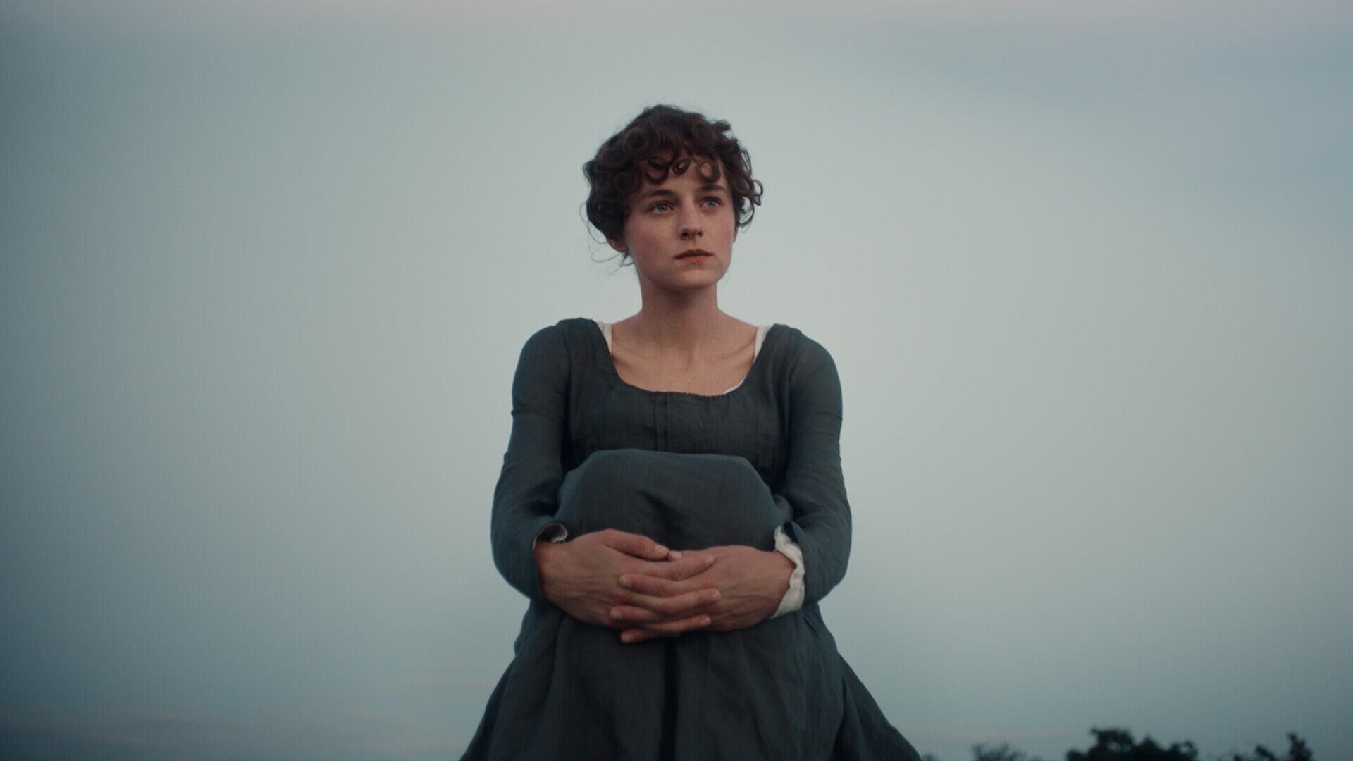 Emma Corrin in a dark Regency dress against a misty landscape in Netflix’s Pride and Prejudice (2026), HD desktop wallpaper.