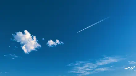 2K Quad HD PC desktop wallpaper of a vivid blue sky with scattered white clouds and a jet contrail streaking across