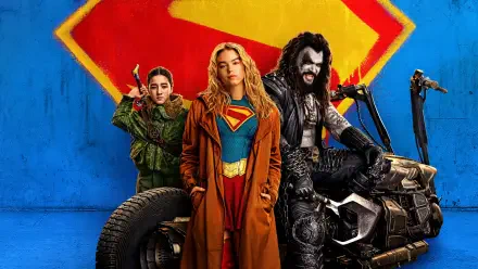 Supergirl (2026) 4K Ultra HD PC desktop wallpaper: Supergirl in blue-and-red costume with trench coat stands centered, flanked by allies and a motorcycle against a blue wall with S emblem.