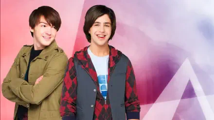 4K Ultra HD PC desktop wallpaper of two smiling young male sitcom stars against a pink-purple geometric backdrop; one in a green jacket, the other in a red plaid hoodie.