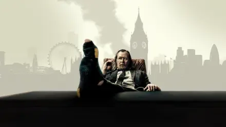 Slow Horses 4K Ultra HD PC desktop wallpaper: a disheveled man in a suit lounges with a foot on a desk, foggy London skyline (Big Ben, London Eye) silhouetted behind him.