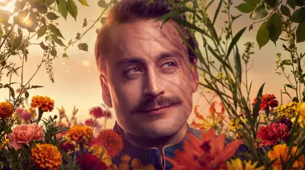 Caesar Flickerman from The Hunger Games, mustached man portrait among autumn flowers, 5K Ultra HD PC desktop wallpaper.
