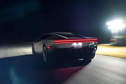Tesla Roadster electric sports car speeding at night, shown in a cinematic 2K Quad HD desktop wallpaper.