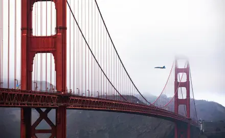 Blue Angels Boeing F/A-18E/F Super Hornet flies past the Golden Gate Bridge, a suspension bridge, in this 5K Ultra HD desktop wallpaper.