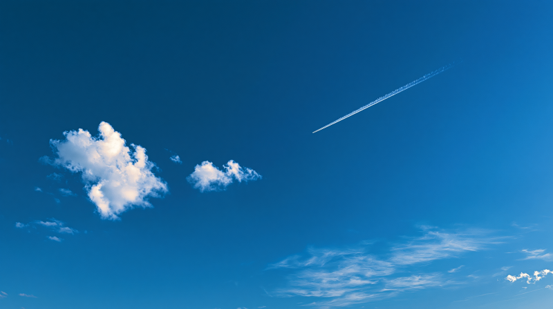 {{ 2K Quad HD PC desktop wallpaper of a vivid blue sky with scattered white clouds and a jet contrail streaking across