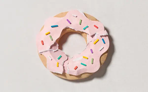 4K Ultra HD PC desktop wallpaper showing a pink-frosted doughnut with rainbow sprinkles on a pale background.