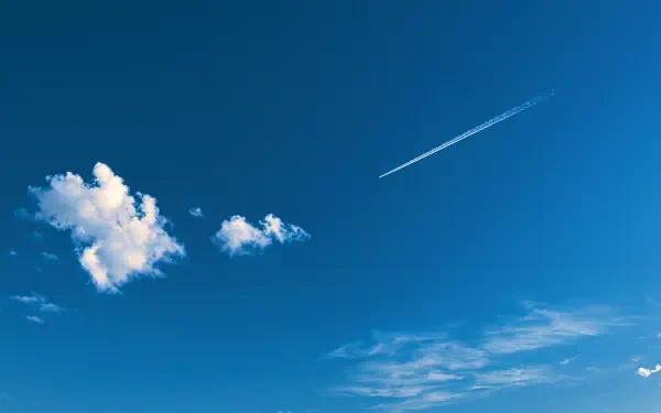 2K Quad HD PC desktop wallpaper of a vivid blue sky with scattered white clouds and a jet contrail streaking across