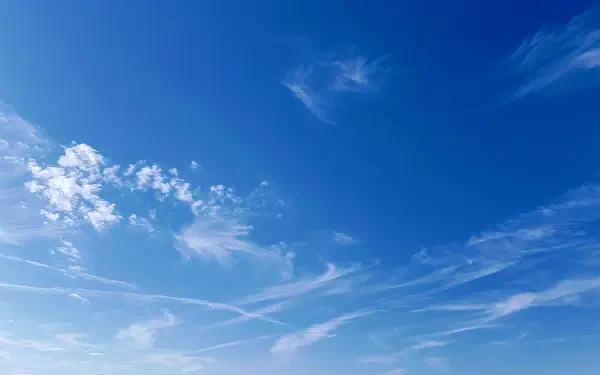 2K Quad HD PC desktop wallpaper: vivid blue sky with wispy white clouds and faint contrails.
