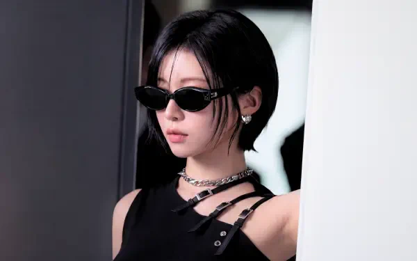 5K Ultra HD wallpaper: k-pop idol–styled Japanese model in sleek black The Matrix–inspired outfit with narrow sunglasses, cool moody studio background.