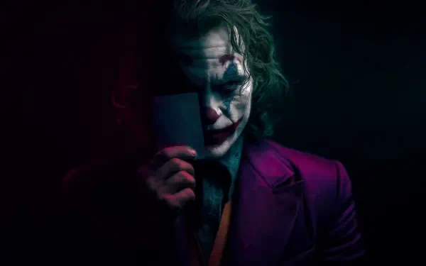 4K Ultra HD PC wallpaper of the Joker in film-inspired makeup and purple suit, holding a mask that hides half his face, moody shadows and dramatic lighting.
