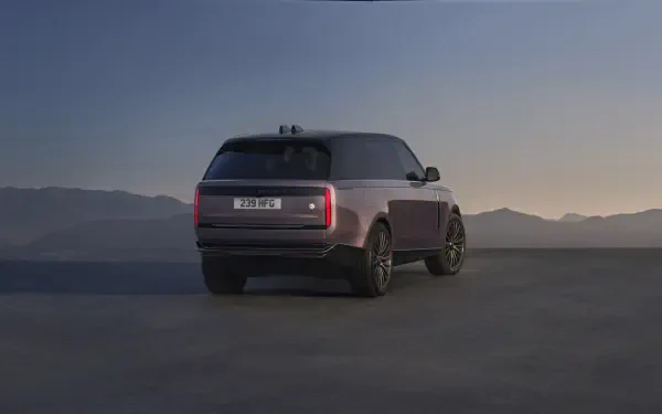 Rear three-quarter view of a Range Rover Electric SUV on a flat plain at dusk — 8K Ultra HD PC desktop wallpaper/background of the electric vehicle.