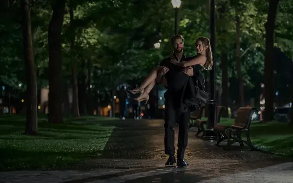 4K Ultra HD PC desktop wallpaper: romantic nighttime park scene of a man carrying his partner beneath lamplight, evoking The Love Hypothesis.