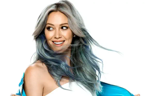 Smiling female celebrity with silver-blue hair and teal jacket on a white background — 4K Ultra HD PC desktop wallpaper/background.