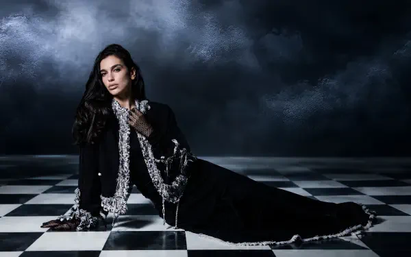 Moody portrait of a female singer in a black gown on a checkerboard floor beneath stormy clouds — music-themed 4K Ultra HD PC desktop wallpaper/background.
