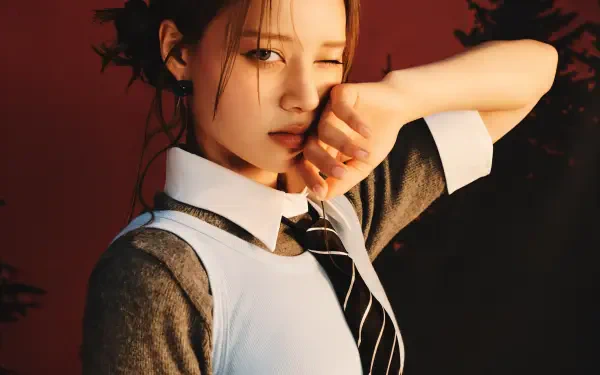 Winking portrait of a woman in a school-style uniform, hand to her mouth, moody Sour Grapes vibe — 4K Ultra HD PC desktop wallpaper/background.
