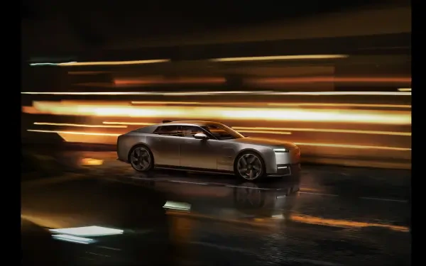 Jaguar Type 01 luxury sedan speeding through city lights at night, 8K Ultra HD PC desktop wallpaper and background.