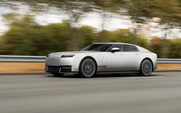 Jaguar Type 01 luxury coupé speeding along a road in a 5K Ultra HD PC desktop wallpaper background.
