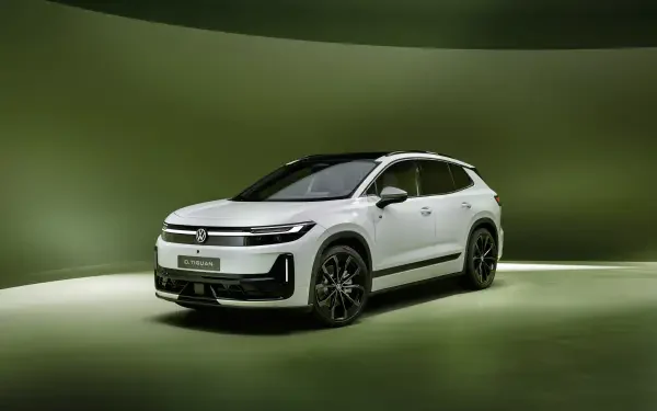 White Volkswagen ID. Tiguan electric SUV on a green studio backdrop, 4K Ultra HD PC desktop wallpaper.