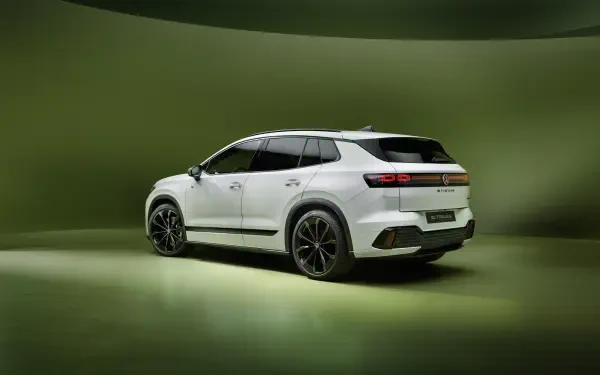 White Volkswagen ID. Tiguan electric SUV in a green studio, featured in a 4K Ultra HD PC desktop wallpaper background.