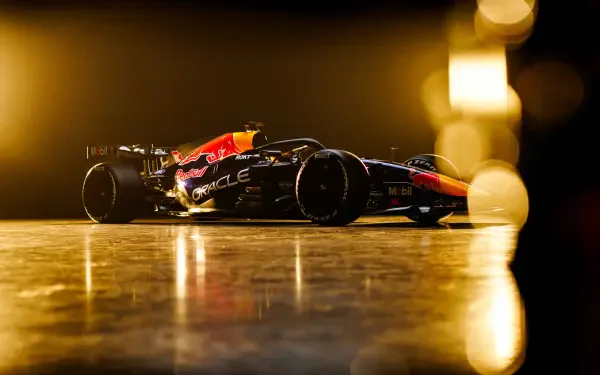 Red Bull Racing RB22 F1 race car speeding through a golden-lit track, 4K Ultra HD PC desktop wallpaper and background.