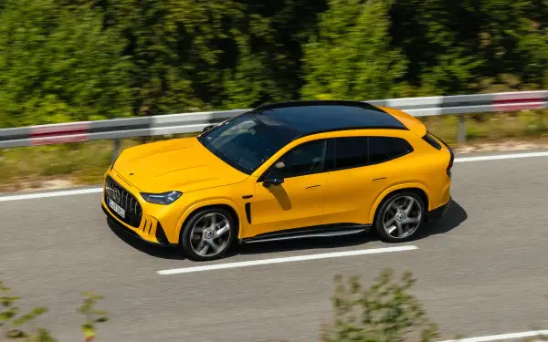Yellow Mercedes-AMG GT SUV driving on a forest road, 2K Quad HD desktop wallpaper featuring a Mercedes-Benz performance car.