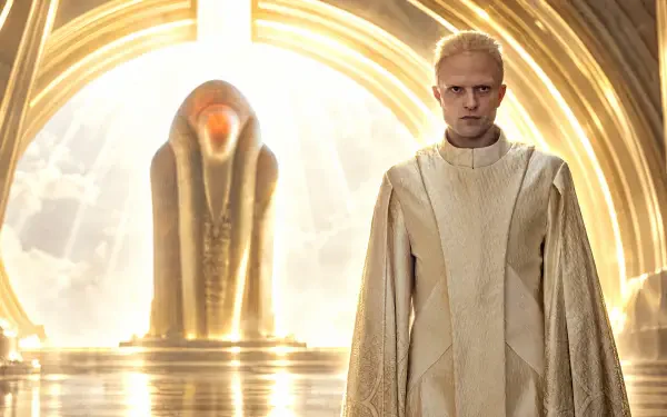 Robert Pattinson in cream robes before a glowing sci-fi monument in Dune: Part Three, 4K Ultra HD PC desktop wallpaper and background.
