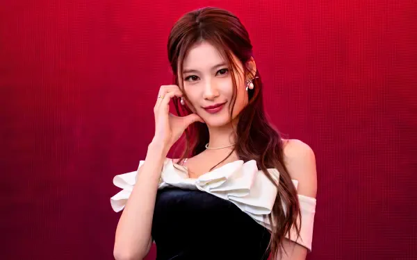 TWICE and MiSaMo’s Sana, Japanese model and K-pop singer, poses against a red backdrop in a 5K Ultra HD desktop wallpaper.