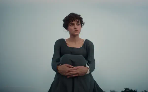 Emma Corrin in a dark Regency dress against a misty landscape in Netflix’s Pride and Prejudice (2026), HD desktop wallpaper.