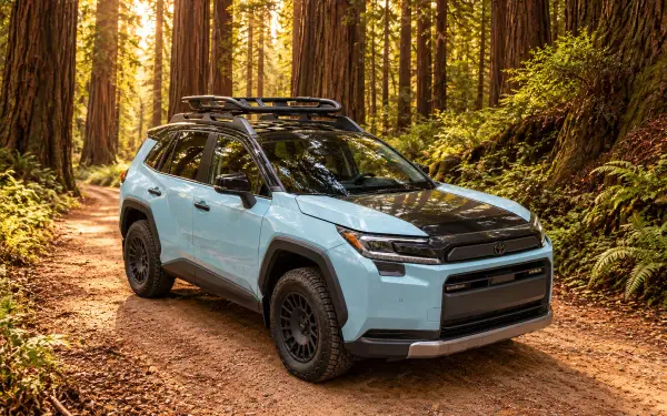 Toyota RAV4 Woodland Concept SUV parked on a forest trail, shown in a 2K Quad HD PC desktop wallpaper.