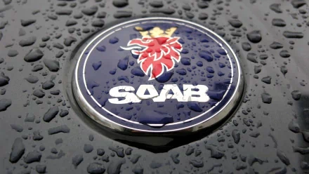 Close-up of Saab vehicle emblem with raindrops on a glossy surface, HD PC desktop wallpaper and background.