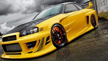 HD PC desktop wallpaper of a yellow Nissan vehicle: modified sports coupe with black hood, rear wing and orange-accent wheels on wet pavement beneath a dramatic cloudy sky.