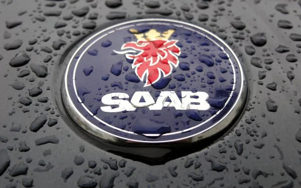 Close-up of Saab vehicle emblem with raindrops on a glossy surface, HD PC desktop wallpaper and background.