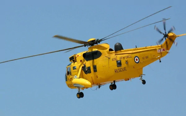 HD desktop wallpaper featuring a yellow Sikorsky SH-3 Sea King military rescue helicopter flying against a clear blue sky.