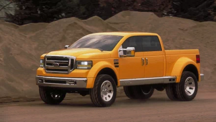 Yellow Ford Mighty F-350 pickup parked against sand mounds, HD PC desktop wallpaper background.