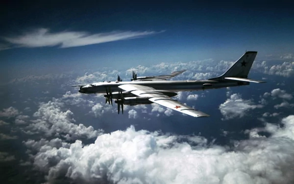 A Tupolev Tu-95 military aircraft flies gracefully above the clouds, showcasing its powerful design against a stunning blue sky, creating a striking HD desktop wallpaper.