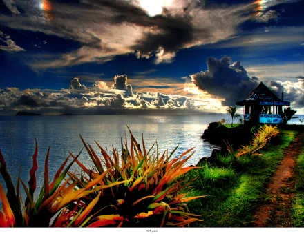 HDR photography captures a vibrant sunset over the ocean, with a coastal path leading to a small hut, framed by lush plants, rendered as an HD PC desktop wallpaper.