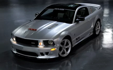 HD desktop wallpaper of a sleek silver Ford Mustang parked on a glossy floor, showcasing its sporty design and aggressive front grille.