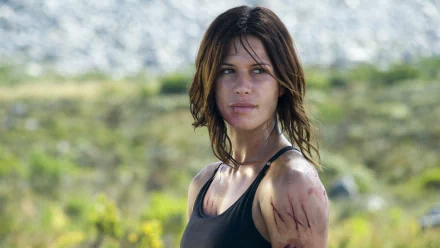 HD PC desktop wallpaper featuring Rhona Mitra from the movie Doomsday, showing her in a rugged outdoor setting with scratches on her arm.