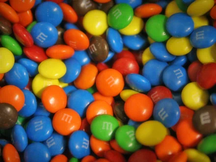 A vibrant HD desktop wallpaper featuring a colorful assortment of M&M's candy.