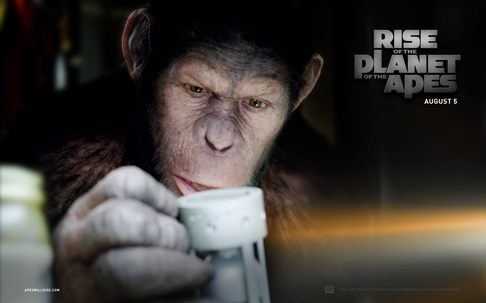 HD desktop wallpaper from the movie Rise of the Planet of the Apes featuring a close-up of a curious ape holding a device, with the film title and release date displayed.