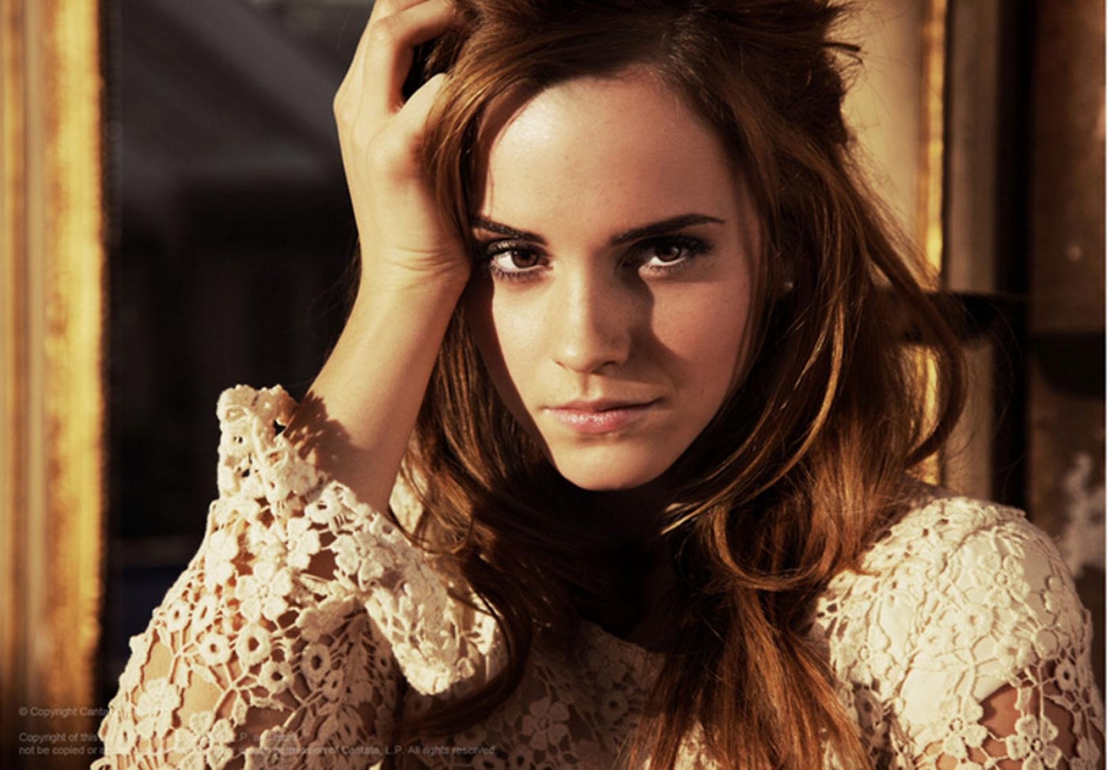 High-definition desktop wallpaper featuring celebrity Emma Watson, showcasing her striking gaze and elegant lace outfit against a softly lit background.