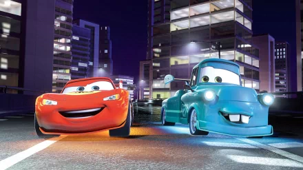 HD PC desktop wallpaper featuring Lightning McQueen and Mater from the movie Cars Toons: Mater's Tall Tales against a vibrant nighttime cityscape.