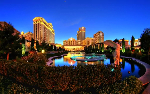 HD PC desktop wallpaper featuring a vibrant man-made Las Vegas nightscape with illuminated buildings and reflective water under a deep blue sky.