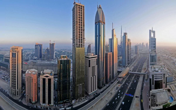 A stunning HD wallpaper showcasing the modern skyline of Dubai, featuring towering skyscrapers and a bustling highway under the soft glow of sunrise.