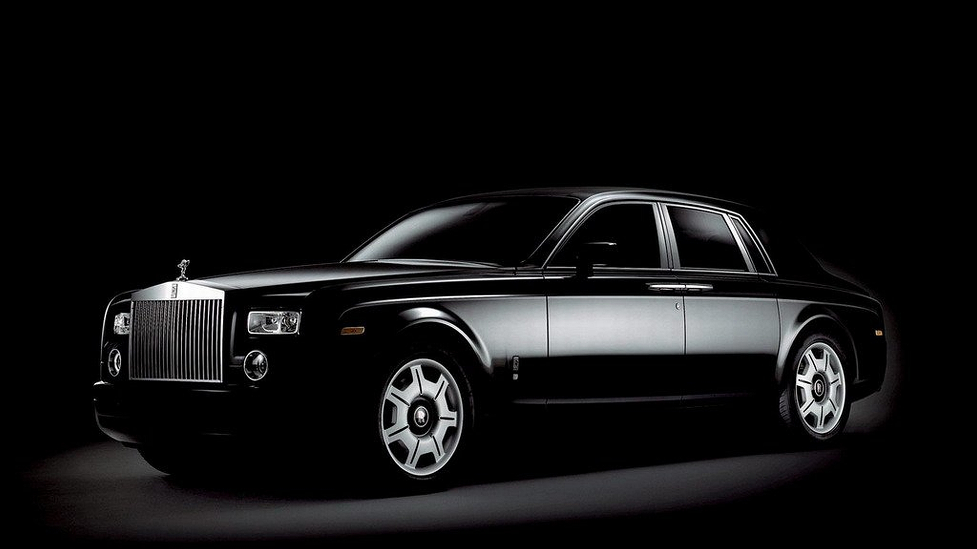 Luxurious Rolls-Royce parked in scenic landscape.
