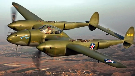 A historic military aircraft flies over a scenic landscape, showcasing its distinctive design and powerful engines. Ideal HD desktop wallpaper for aviation enthusiasts.