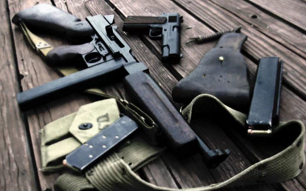 A close-up of various submachine guns and accessories arranged on a wooden surface, presented as an HD desktop wallpaper and background.