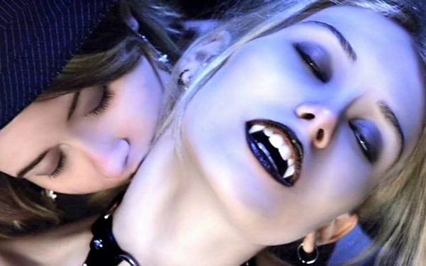 HD desktop wallpaper featuring a beautiful demon and a vampire in a fantasy setting; one figure with fangs exposed, and another biting their neck.