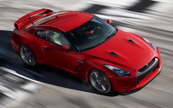 A sleek red Nissan sports car captured in motion, showcased as a 4K Ultra HD PC desktop wallpaper and background.