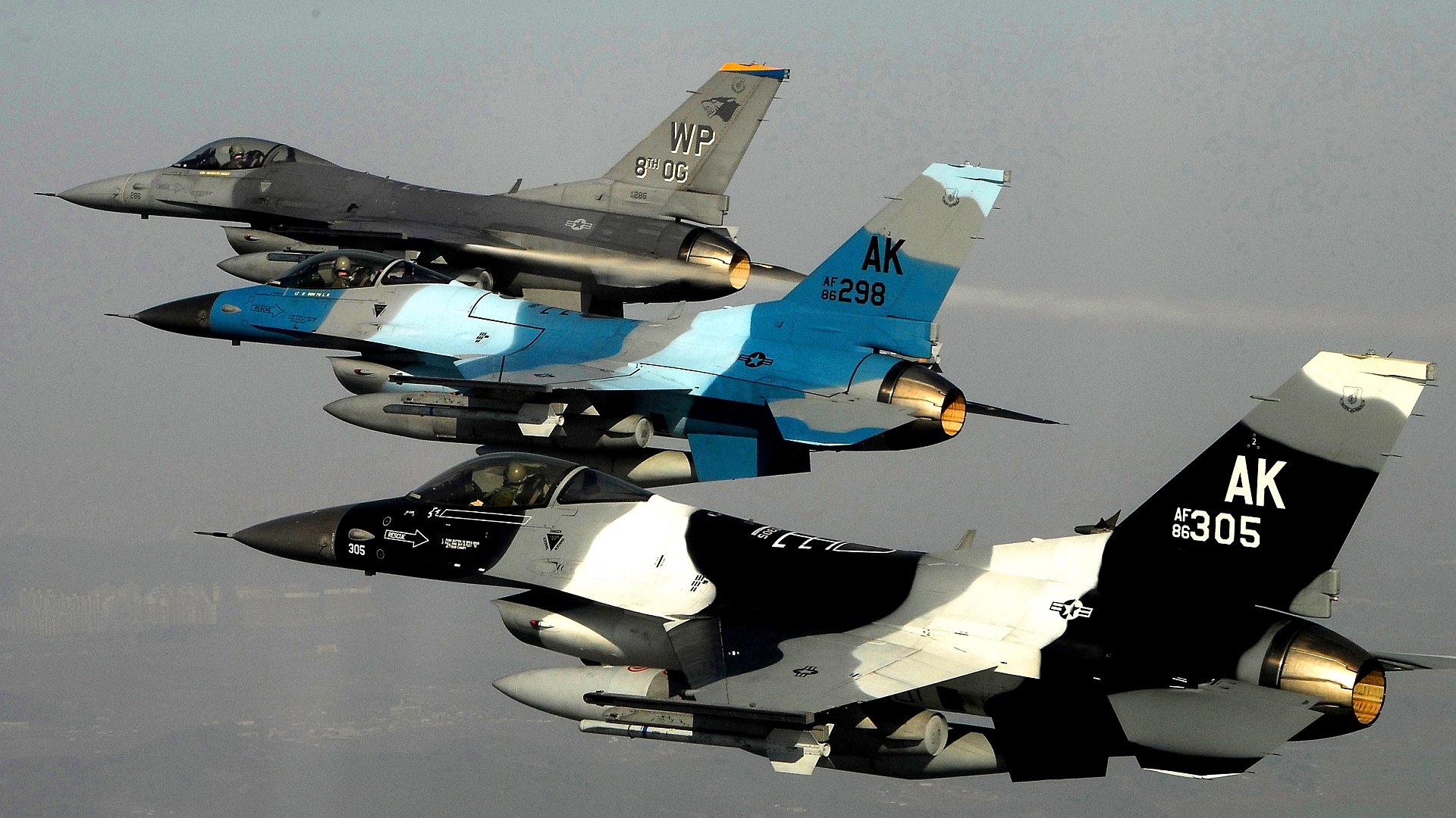 Three General Dynamics F-16 Fighting Falcon jet fighters in flight against a clear sky, shown in HD quality as a military-themed desktop wallpaper.